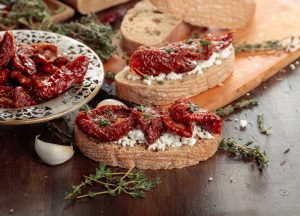 Bruschetta integral com creme de ricota e tomate seco