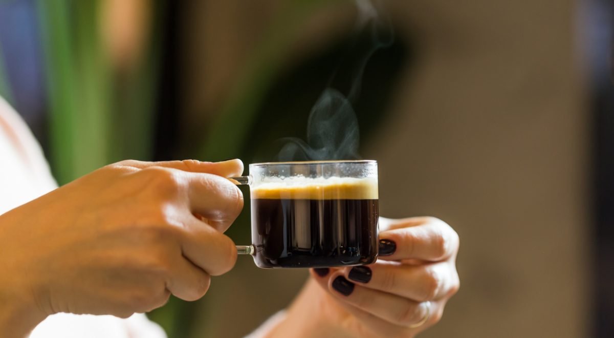 Lensmir - iStock - Imagem ilustrativa de pessoa segurando xícara de café