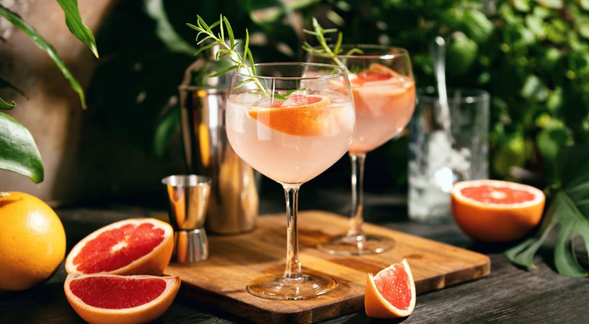 fortyforks/IStock - Imagem ilustrativa de coquetel de toranja rosa e gin com alecrim servido em uma taça.