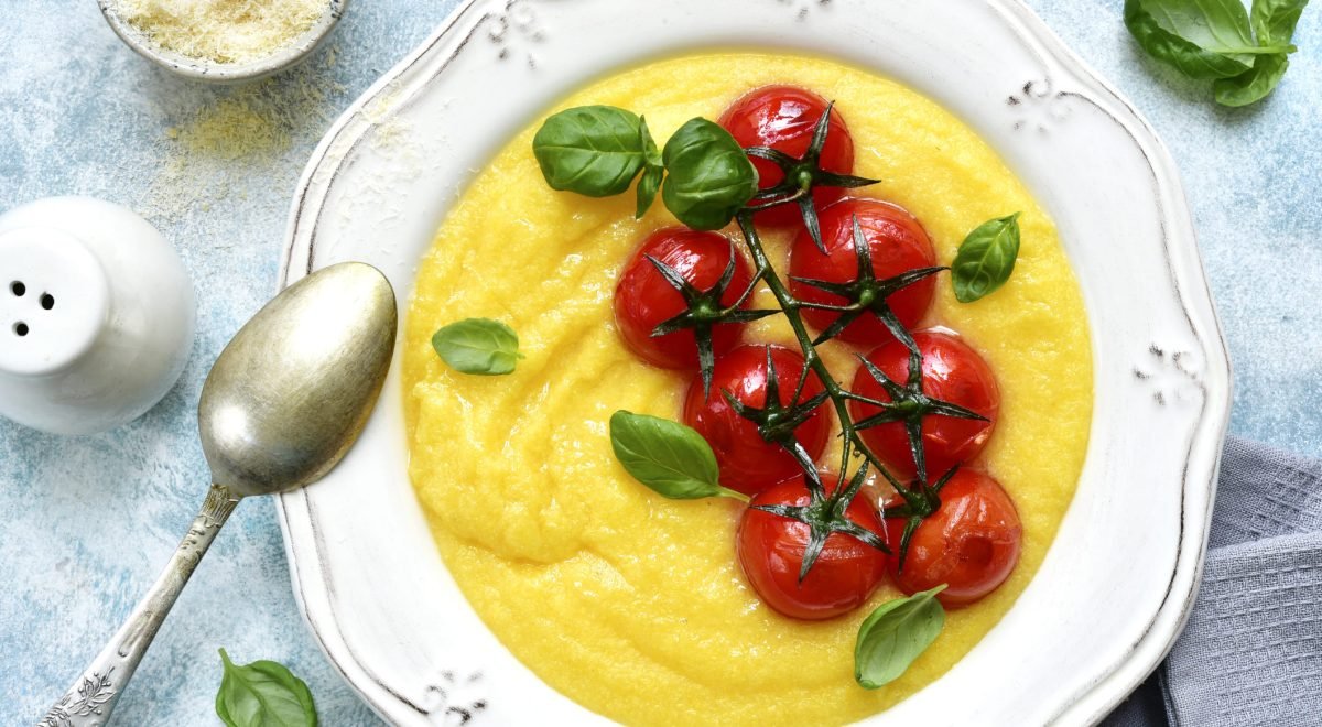Polenta - iStock - Imagem ilustra polenta em prato branco com tomates em cima