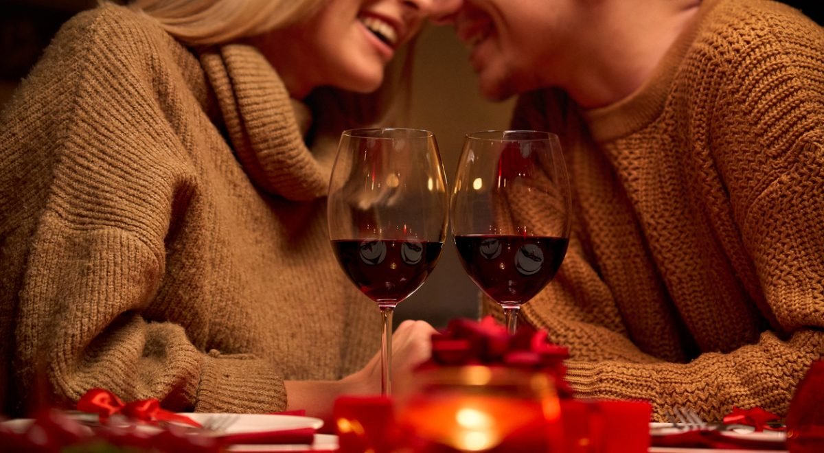 Casal celebra o Dia dos Namorados - iStock - Imagem ilustra casal brindando com taça de vinho em jantar especial