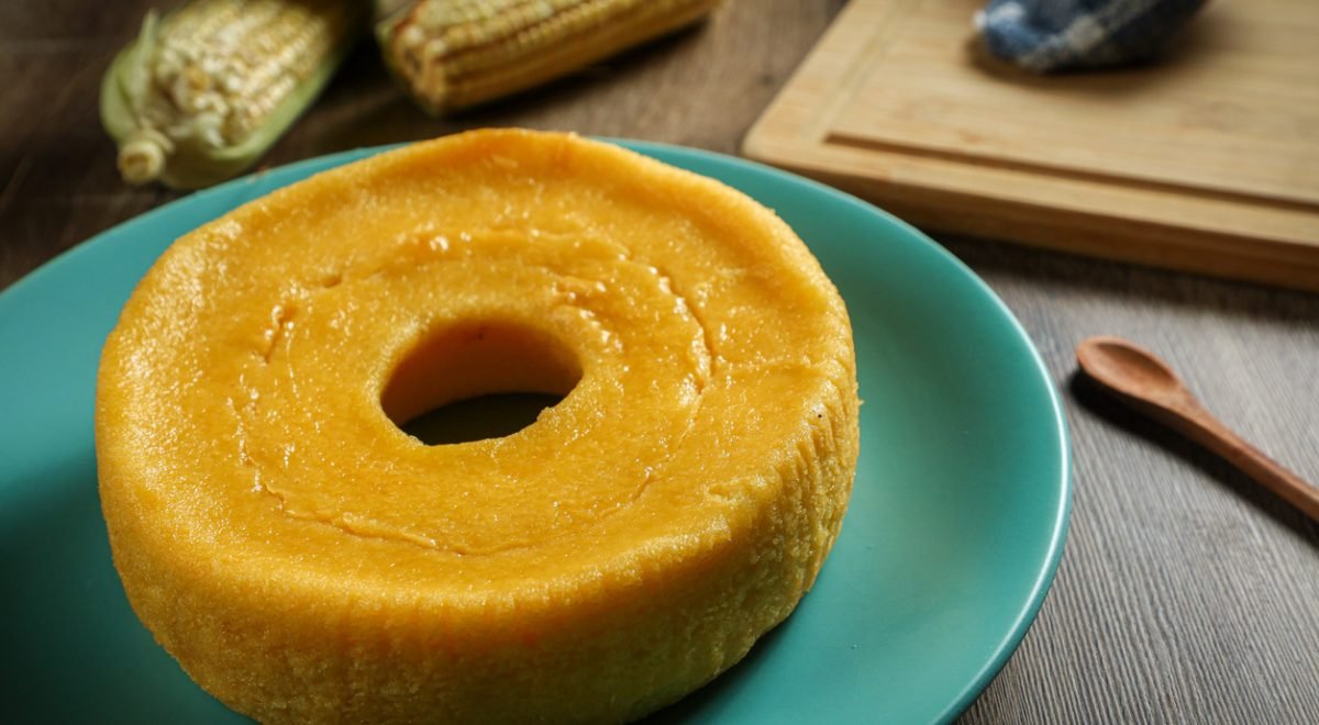 Bolo pamonha - iStock - Imagem ilustra bolo de pamonha em prato verde com milho ao lado