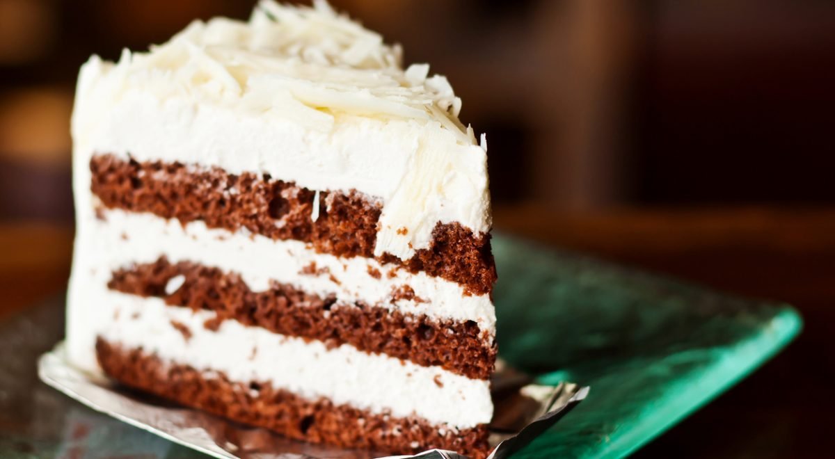 Bolo de chocolate com ninho - iStock - Imagem ilustra bolo de chocolate fatiado com cobertura