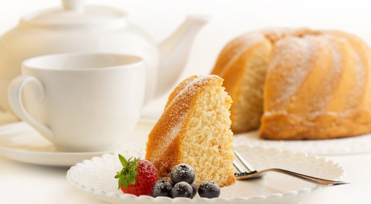 Bolo - iStock - Imagem ilustra café da tarde com fatia de bolo em prato branco e frutas