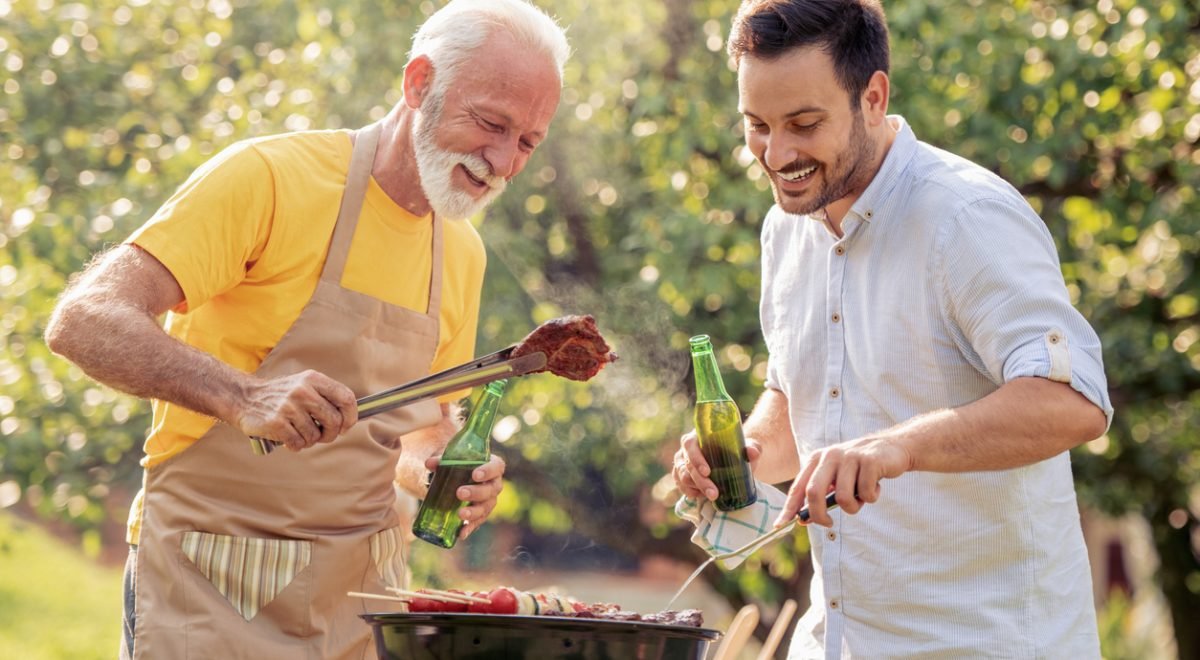 Pai e filho participando de um churrasco - iStock