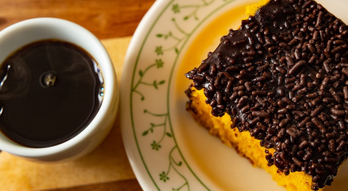 Bolo de cenoura - iStock - Imagem ilustra bolo de cenoura em prato ao lado de café preto