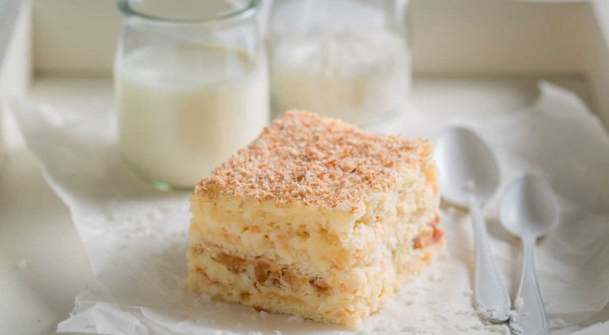 Bolo de coco - iStock - Imagem ilustra bolo de coco cortado em prato branco