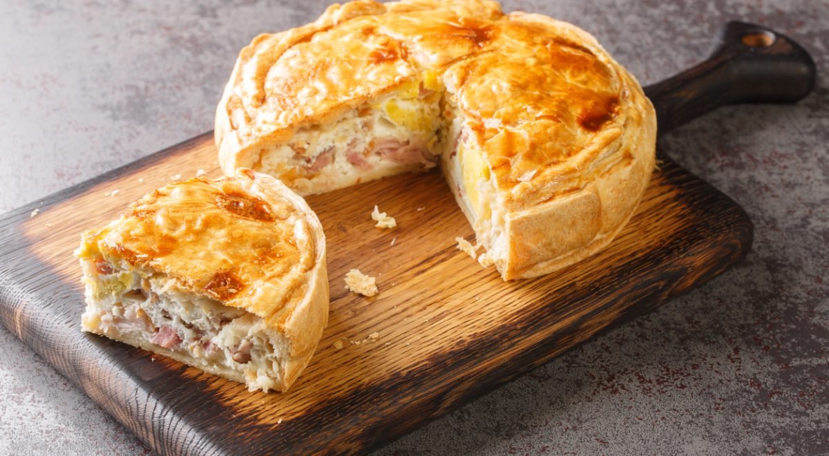 Torta salgada - iStock - Imagem ilustra torta salgada fatiada em tábua de madeira