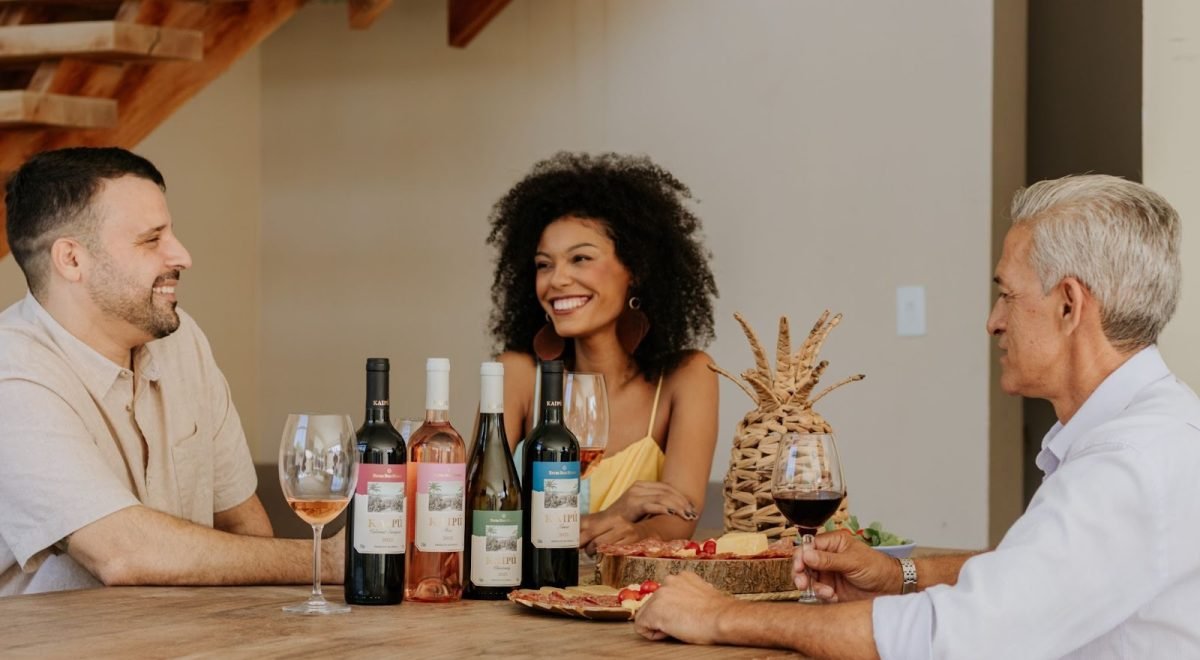 Izabelly Custódio e Rhafaela Lima/Divulgação - Wine - Imagem de três pessoas tomando vinhos em uma mesa