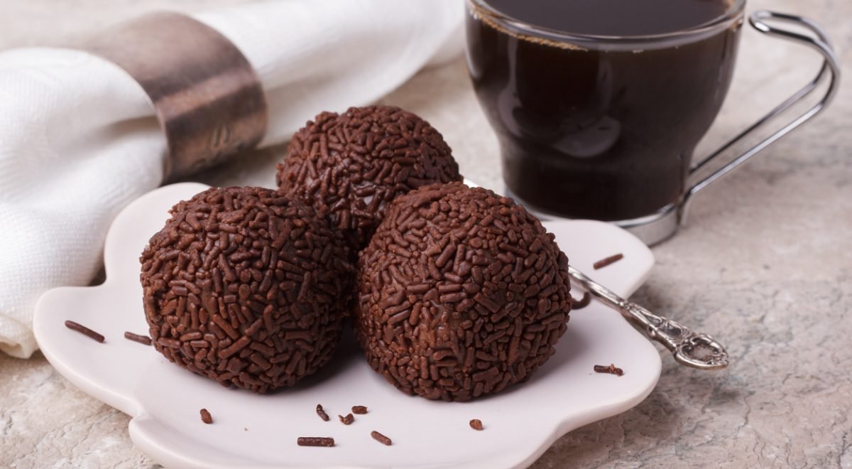 Brigadeiro com café - iStock - Imagem ilustra brigadeiros em prato branco perto de café