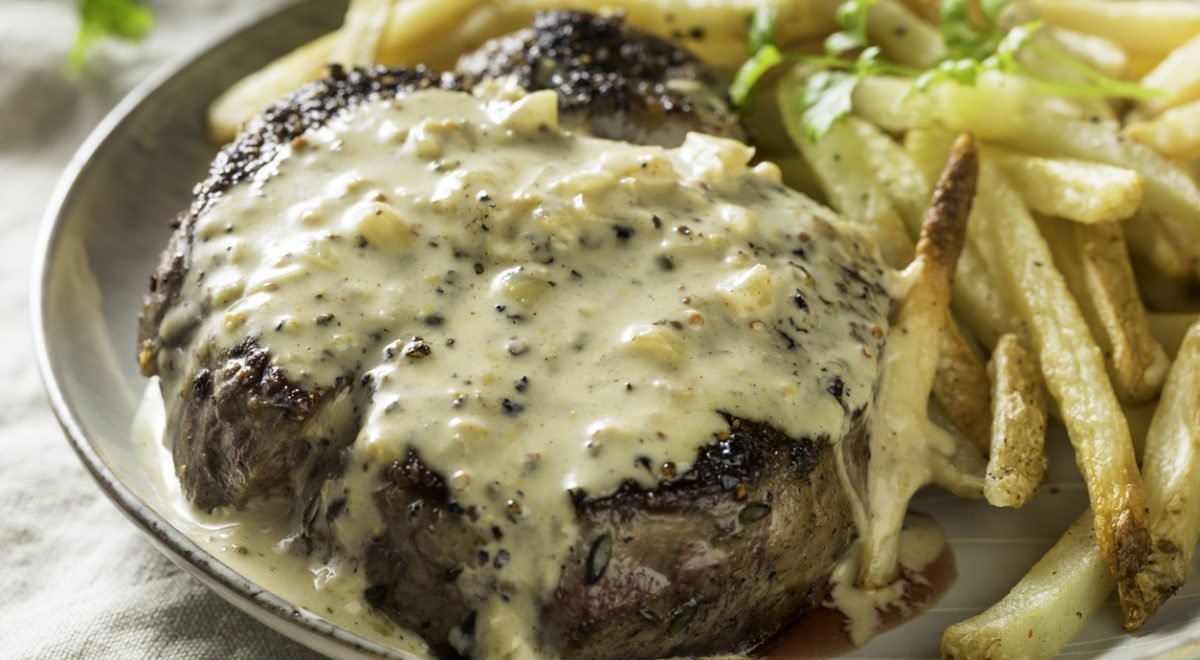 Bife ao molho de mostarda - iStock - Imagem ilustra bife ao molho de mostarda ao lado de batatas-fritas